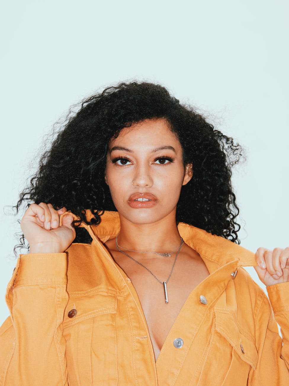 Beautiful Curly hair fashion model posing in yellow denim jacket